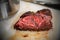 Sliced piece of baked beef hanger steak on kitchen board