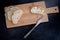 Sliced pieces go ciabatta bread on the wooden cutting board with butter on it and buttered knife next to it.