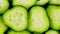 Sliced pieces of green cucumber stacked on a hill rotate. Fresh sliced cucumber pieces are rotating.