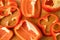 Sliced pieces, parts, lobes of sweet pepper, red, scattered on a wooden board