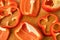 Sliced pieces, parts, lobes of sweet pepper, red, scattered on a wooden board