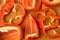 Sliced pieces, parts, lobes of sweet pepper, red, scattered on a wooden board