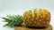 Sliced pineapple on an insulated wooden board on a white background with space at the top of the image. Healthy food concept