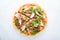 Sliced pizza with prosciutto parma ham, arugula (salad rocket) and parmesan on white background top view