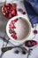 Sliced pomegranate and homemade fresh yoghurt with forest fruits and cereal. White marble pattern background.