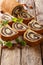 Sliced poppy roll with raisins, decorated with mint close-up on parchment. vertical