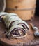 Sliced poppy seeds strudel on rustic desk with fork next to cake