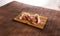 sliced prosciutto on a wooden board on empty table. pork ham on a brown background. composition meat delicacy.