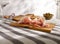 sliced prosciutto on a wooden board. pork ham on a light background. composition meat delicacy with olives and bread.