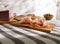 sliced prosciutto on a wooden board. pork ham on a light background. composition meat delicacy with olives and bread.