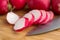 Sliced radish on cutting board with knife