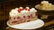 Sliced raspberry cake with butter cream behind the vitrine. Bakery window with cakes. Close up