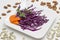 Sliced red cabbage on white plate. Almond and pumpkin seeds