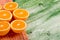 Sliced ripe appetizing orange on green table