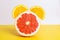 Sliced ripe grapefruit and orange in the shape of an alarm clock.