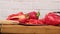 Sliced ripe red peppers on a wooden board, camera move to the right