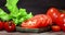 Sliced ripe tomato on a cutting Board with greens.