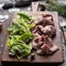 Sliced Roast Beef with Fresh Salad Leaves, Olives and Blue Cheese on Wooden Board. Holiday Appetizer