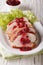 Sliced roasted turkey breast with cranberry sauce on a plate close-up. vertical