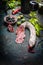 Sliced Salami stick with antipasti , red wine and grape leaves on dark vintage background.