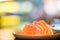 Sliced salmon sashimi served on wooden platter, Japanese food delicious menu, bokeh blur background with copy space