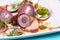 Sliced salted and smoked fish, greens, seasonings and fresh vegetables with onions