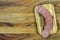 Sliced sausage on mini cutting board with wooden background