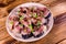 Sliced scomber fish with green onion on a ceramic plate on wooden table