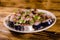 Sliced scomber fish with green onion on a ceramic plate on wooden table