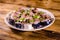 Sliced scomber fish with green onion on a ceramic plate on wooden table