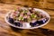 Sliced scomber fish with green onion on a ceramic plate on wooden table