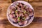 Sliced scomber fish with green onion on a ceramic plate on wooden table. Top view