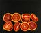 Sliced Sicilian red oranges on black stone background. Top view