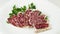 Sliced smoked sausage.Salami,decorated with branches of parsley.