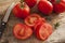 Sliced succulent red tomatoes beside serrated knife