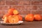 Sliced sweet persimmon kaki in a bamboo sieve basket on dark wooden table with red brick wall background, Chinese lunar new year