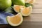 Sliced sweetie fruit on wooden table, space for text