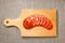 Sliced tomato on wooden cutting board with sacking