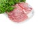 Sliced uncooked pork on dish against the background of parsley