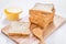 Sliced whole wheat bread with butter on white wooden table