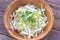 Sliced young cabbage salad in bamboo bowl