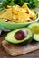 Sliced â€‹â€‹avocado on a wooden board and tortilla corn chips