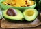 Sliced â€‹â€‹avocado on a wooden board and tortilla corn chips