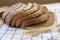 Sliced â€‹â€‹brown bread with spices, close-up, spikelet of wheat, light napkin