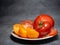 Sliced â€‹â€‹juicy tomatoes of different varieties on a plate. Greenhouse orange tomatoes. Healthy food. Vegetarian food
