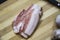 Sliced â€‹â€‹pieces of bacon. Ukrainian traditional meal. Slices of salted pork lardon with  knife on the wooden background