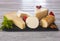 Slices of assorted French, Spanish and Italian cheese on a dark board, served with fruit, wooden background