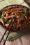 Slices of beef fried with sesame seeds and carrots closeup. Vert