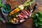 Slices beef steak in frying pan with vegetables top view