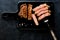 Slices beef Steak Ribeye with salt on a black cutting board and meat fork